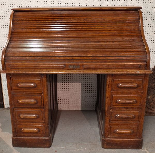 A late 19th century oak roll top pedestal desk, with eight drawers about the knee, 127cm wide x 125cm high.  ROST