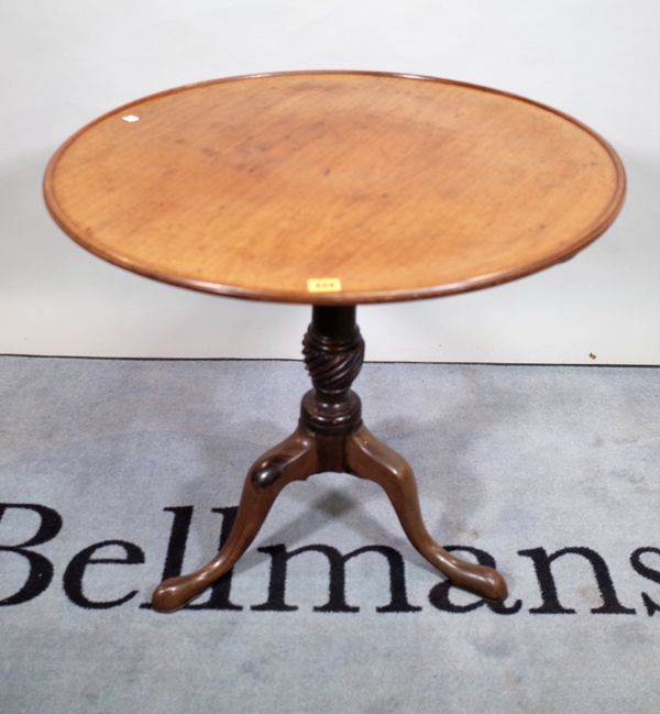 A late George III mahogany tripod table, with a circular dished top, on downswept pad supports, 75cm wide x 70cm high.