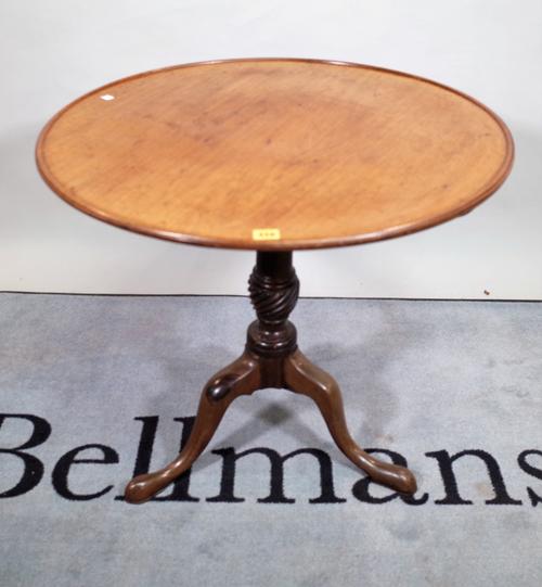 A late George III mahogany tripod table, with a circular dished top, on downswept pad supports, 75cm wide x 70cm high.