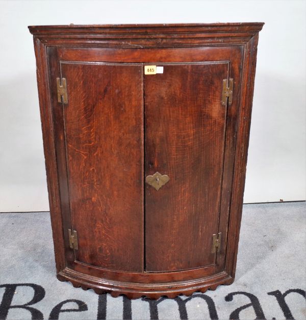 An 18th century oak hanging bowfront two door cabinet, 68cm wide x 91cm high.