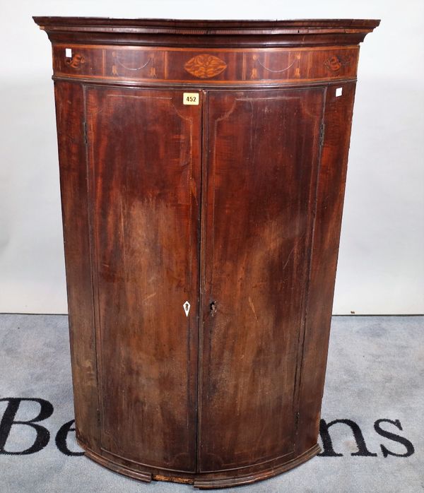 A late George III inlaid mahogany bowfront hanging corner cupboard, 76cm wide x 116cm high.  E1