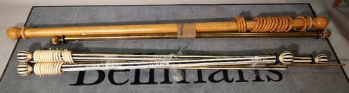 A group of three blue and white painted curtain rails, (one lacking ends), the largest 185cm wide, a stained beech rail, 210cm long and a brass rail,