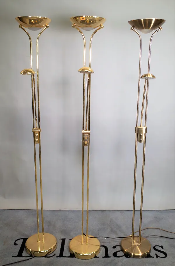 A group of three 20th century brass floor standing lamps, each with angle poise light, 181cm high (3).   E1
