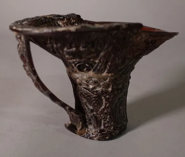 An early 20th century Chinese carved horn libation cup, 16cm wide x 10cm high, (a.f). CAB