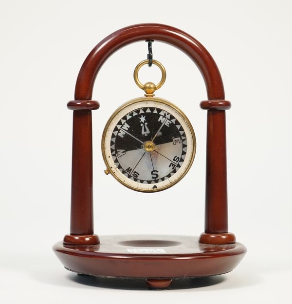 A Brass cased pocket barometer compass compendium by James Lucking & Co Opticians Birmingham and Leeds, 4.8cm diameter, on a later wooden stand. Illus