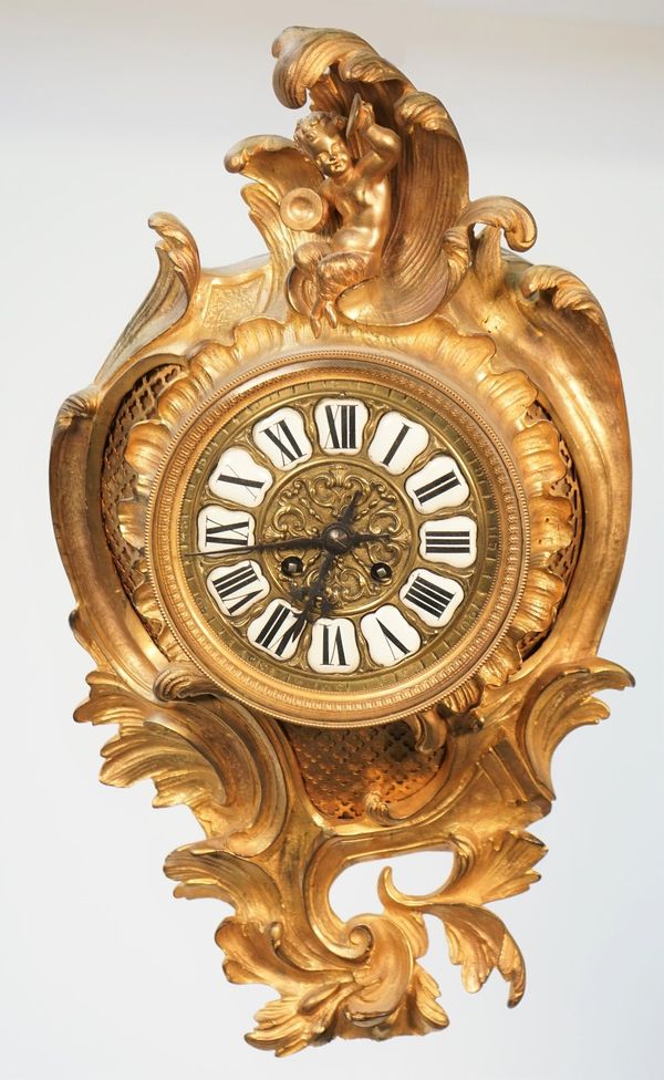 A French gilt Louis XV style gilt metal cartel clock, late 19th century, with satyr finials and foliate cast, enamelled numerals and two train movemen