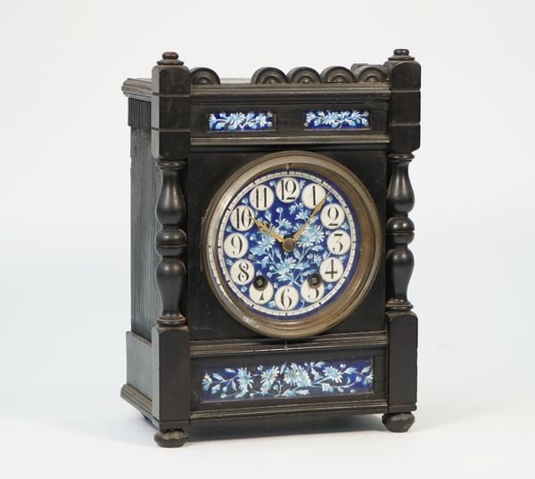 A Liberty style Arts & Crafts mantel clock, the ebonised case with inset foliate painted porcelain dial and plaques enclosing a two train movement wit