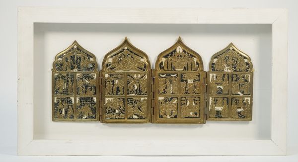 A Russian brass Quadriptych, 19th century, of four arched hinged panels, each with four major feasts surmounted by the crucifixion, New Testament, Tri