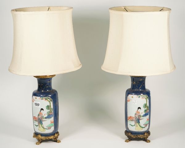 A pair of gilt metal mounted famile verte powder blue ground porcelain vases, decorated with Asian figures, converted to table lamps, with shades, vas