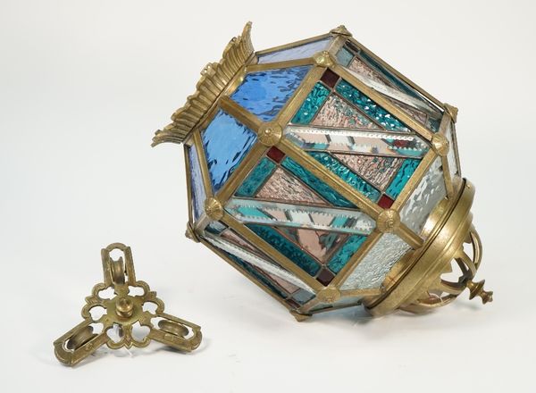 A Victorian brass and glass hall lantern of Gothic form, with pierced dome finial over an octagonal body with inset coloured glass panels with matchin