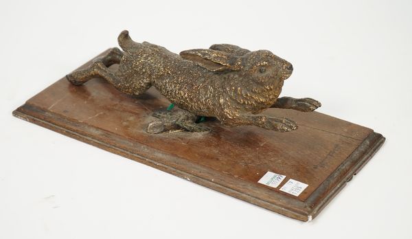 An Austrian cold painted bronze animalier paper clip, late 19th century, in the form of a hare, on an oak plinth, hare 25cm, (a.f.).