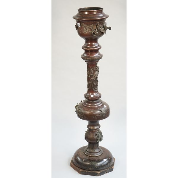 A Chinese bronze jardiniere and stand, of sectional form, decorated with flora and fauna and mounted on a wooden base, 116cm high overall.