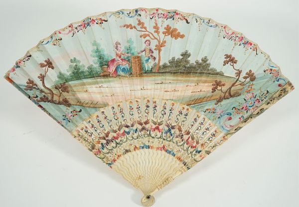 A French painted paper fan, late 18th century, detailed with gallant and companion against painted, pierced and carved ivory sticks, 27cm.