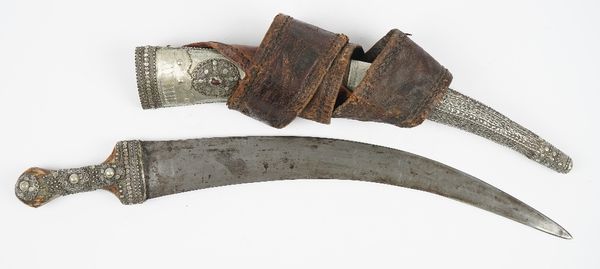 A Saudi Arabian long knife, 19th century, with curved steel blade, 40cm and white metal mounts in a matching scabbard and leather belt.