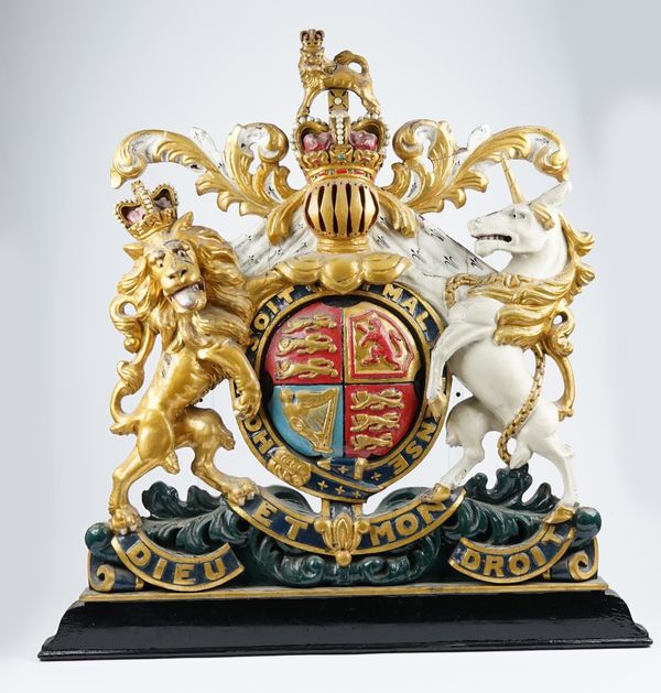 A Polychrome painted carved wooden British warrant or crest, late 19th/ early 20th century, depicting lion and unicorn flanking a shield form crest wi