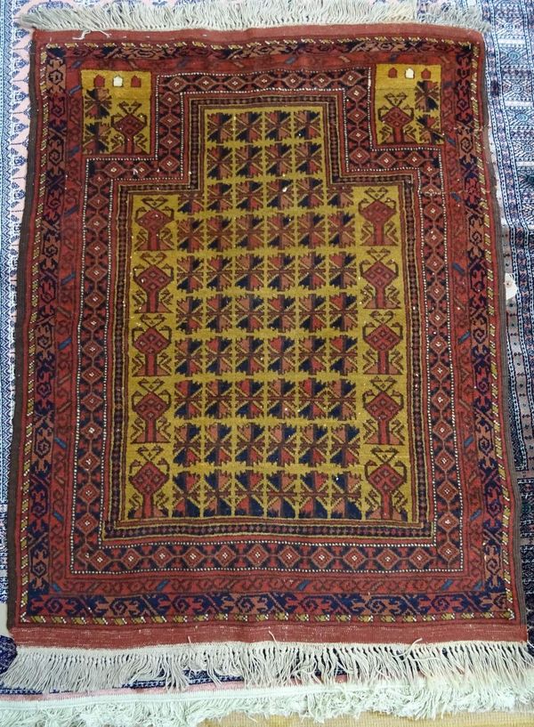 A Beluche prayer rug, the tan mehrab with rows of stylised flower heads, vases to each side, rising to spandrels above, various borders, 125cm x 96cm.