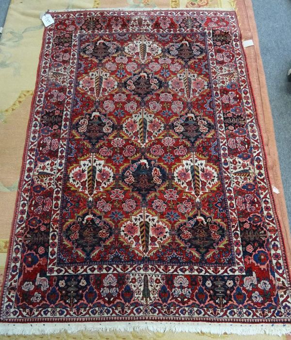 A North West Persian rug, the madder field with a bold angular black medallion and black spandrels, three borders, 260cm x 168cm.