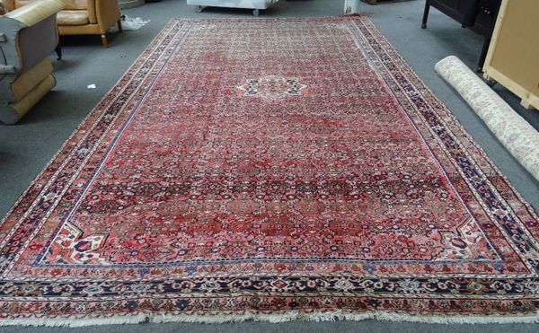 A Fereghan carpet, Persian, the madder field with an allover herate design, three border, 537m x 307cm.