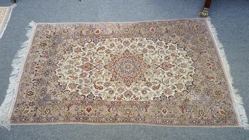 A fine part silk Esfahan rug, Persian, the ivory field with a brown shaped medallion, matching spandrels, all with intricate floral sprays, a brown pa