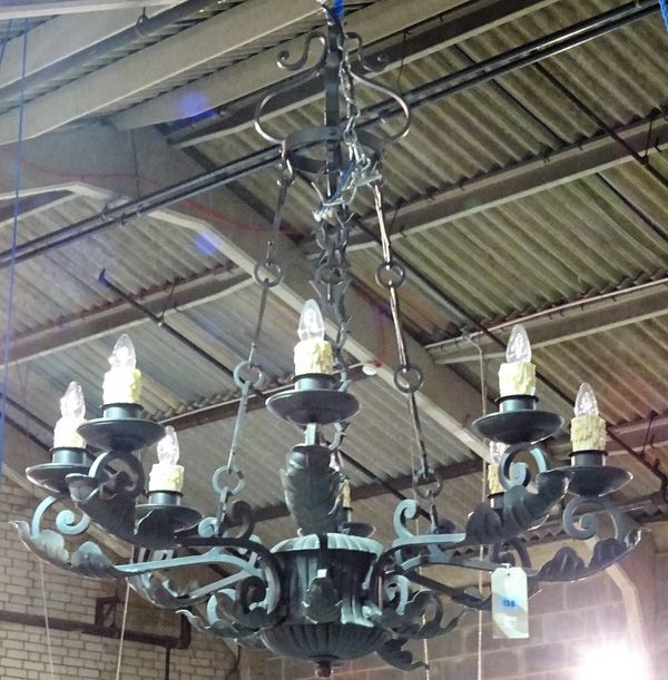 A pair of English wrought iron eight light chandeliers, late 20th century, each cage frame applied with large leaf foliage, suspended by four chains t