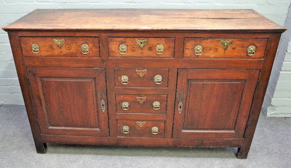 An 18th century oak dresser base with three frieze drawers, over three dummy, flanked by cupboards, 147cm wide x 89cm high.