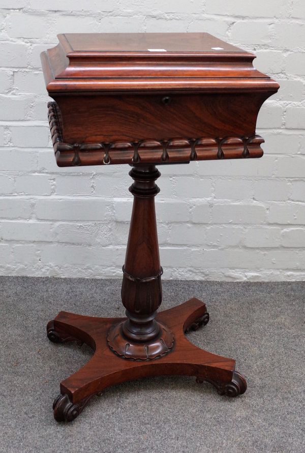 A Regency rosewood teapoy with twin lidded interior, centred by two mixing bowls on turned column and scroll supports, 43cm wide x 80cm long.