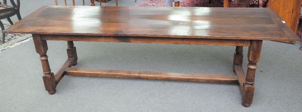 A 17th century style oak refectory table, the plank top on turned supports, 77cm wide x 258cm long.