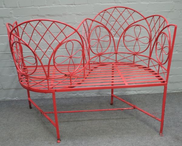 A red painted wrought iron love seat, 110cm wide x 89cm high.