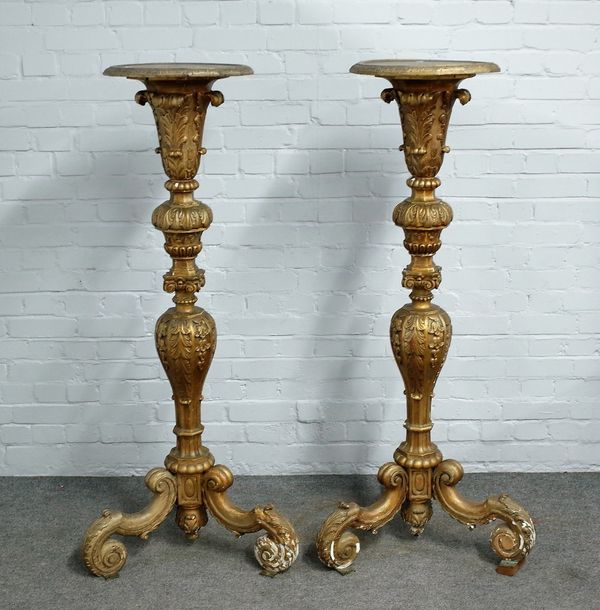 A pair of 18th century style giltwood jardiniere stands, with foliate carved columns on three scroll feet, 143cm high.