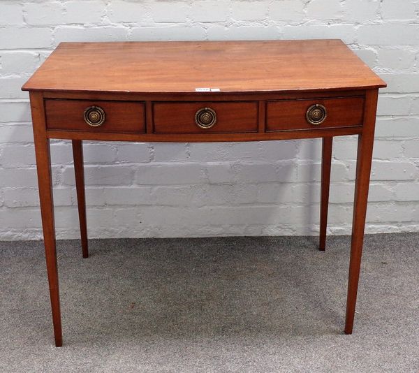 A George III mahogany bowfront side table, with three frieze drawers, on tapering square supports, 84cm wide x 71cm high.