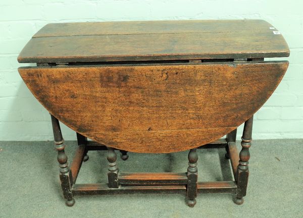 A 17th century oak gate leg dining table on baluster turned supports, 92cm wide x 70cm high.