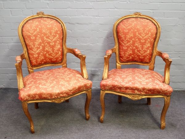 A pair of Louis XV gilt framed open armchairs with serpentine seat and cabriole supports, 60cm wide x 100cm high, (2).