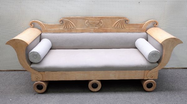 A Biedermeier birch sofa with urn and scroll crest and cornucopia arms on a trio of turned supports, 242cm wide x 102cm high.