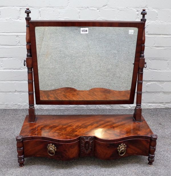 A Regency mahogany toilet mirror with serpentine two drawer base on turned supports, 61cm wide x 68cm high.