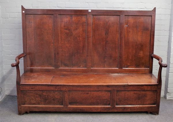 An 18th century oak box seat settle, with a four panel back and open arms, on stile feet, 195cm wide x 139cm high.