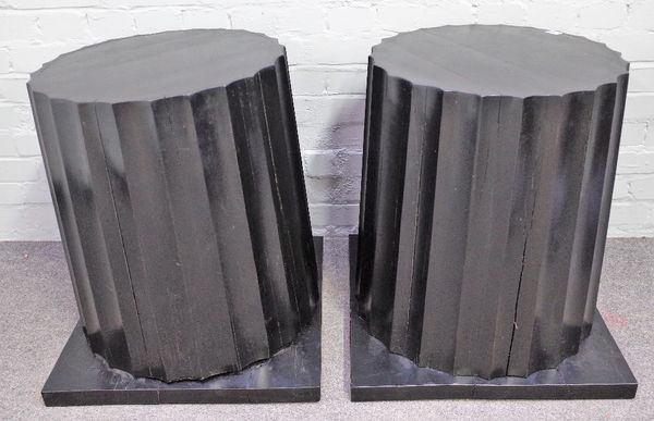 A pair of ebonised hardwood columns, with fluted bodies and square bases, 59cm wide at base x 63cm high, (2).