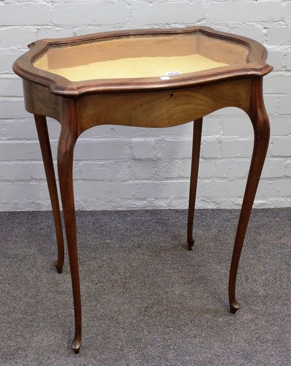 A late 19th century mahogany vertu table, the glazed serpentine top on cabriole supports, 61cm wide x 73cm high.