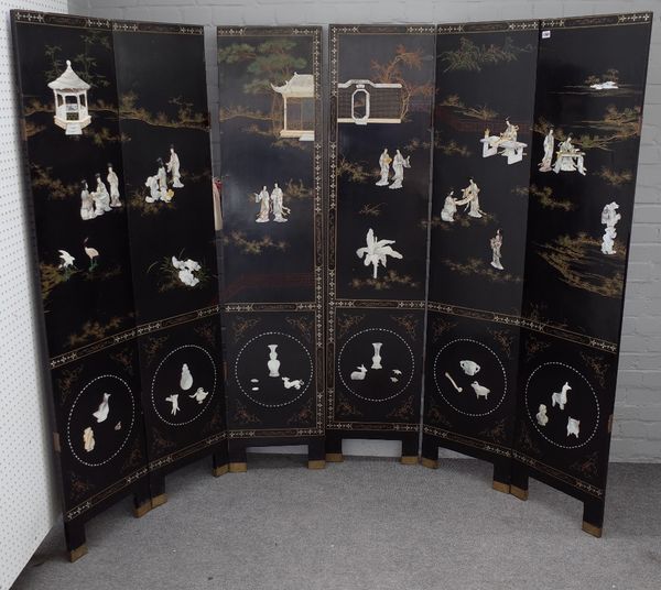 An early 20th century Chinese black lacquer six fold screen decorated in relief with mother-of-pearl figures, 240cm wide x 183cm high.