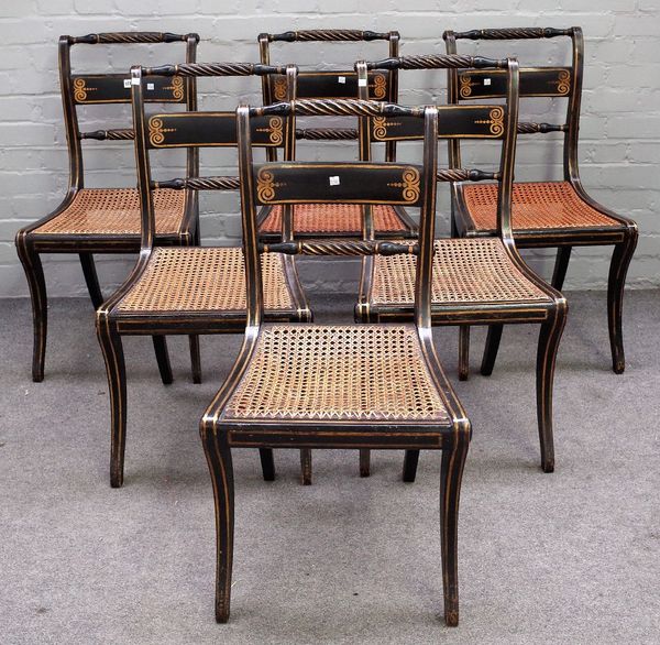 A set of six Regency gilt and ebonised dining chairs, with double rope-twist rails, on sabre supports, 46cm wide x 87cm high.