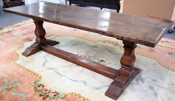 A 17th century style oak refectory table, the cleated plank top on square baluster supports, 81cm wide x 229cm long.