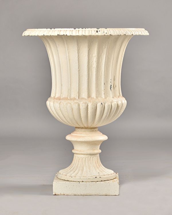 A Victorian white painted cast iron jardiniere, with flared fluted body and turned socle, on square base, 60cm diameter x 76cm high. Illustrated.