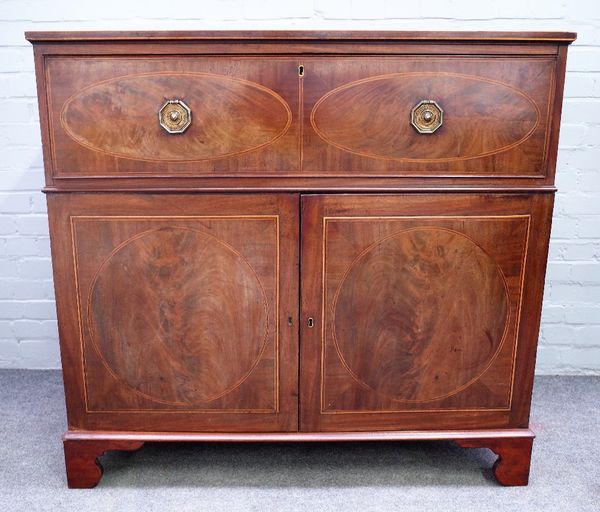 A George III inlaid mahogany rectangular cabinet, the fitted drawer over a pair of cupboards, enclosing linen trays, 199cm wide x 112cm high.