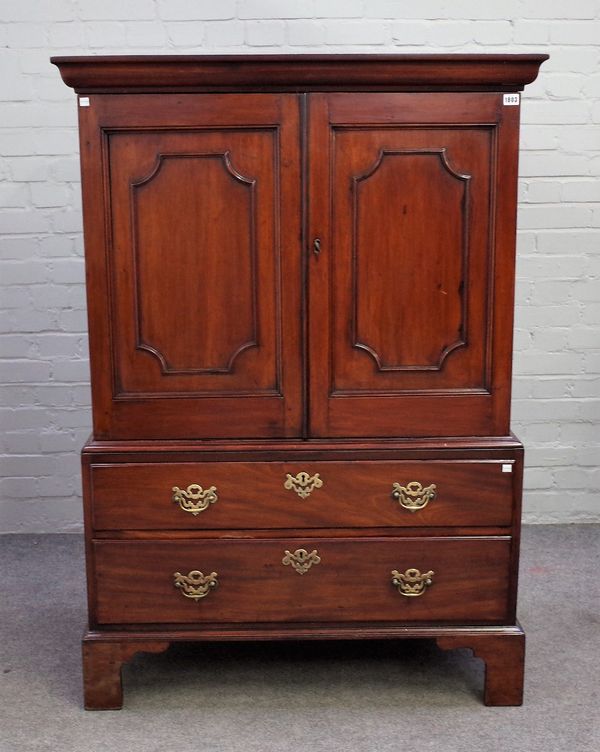 A small early 19th century mahogany linen press, with a pair of panel doors, over a pair of drawers, on bracket feet, 104cm wide x 144cm high.