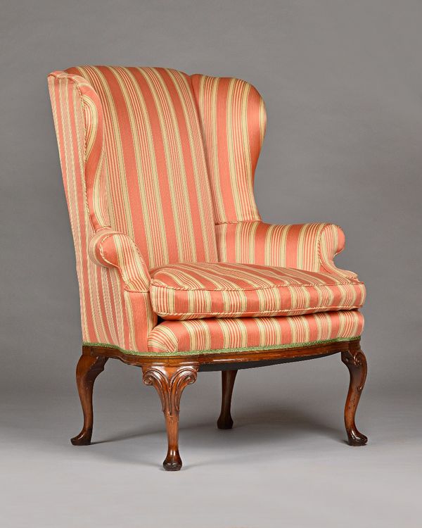 A George I style walnut framed wing back armchair, with bow seat, on scroll capped pad feet, 92cm wide 112cm high. Illustrated.