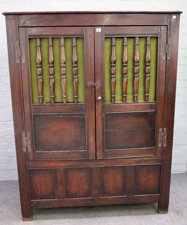 A 17th century oak food cupboard, the pair of doors with spindle turn insets over four panel lower frieze, 125cm wide x 161cm high.