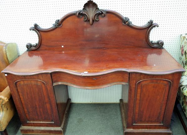 A Victorian mahogany sideboard, the shell and acanthus scroll back over a serpentine top and single frieze drawer, resting on a pair of pedestals, 183