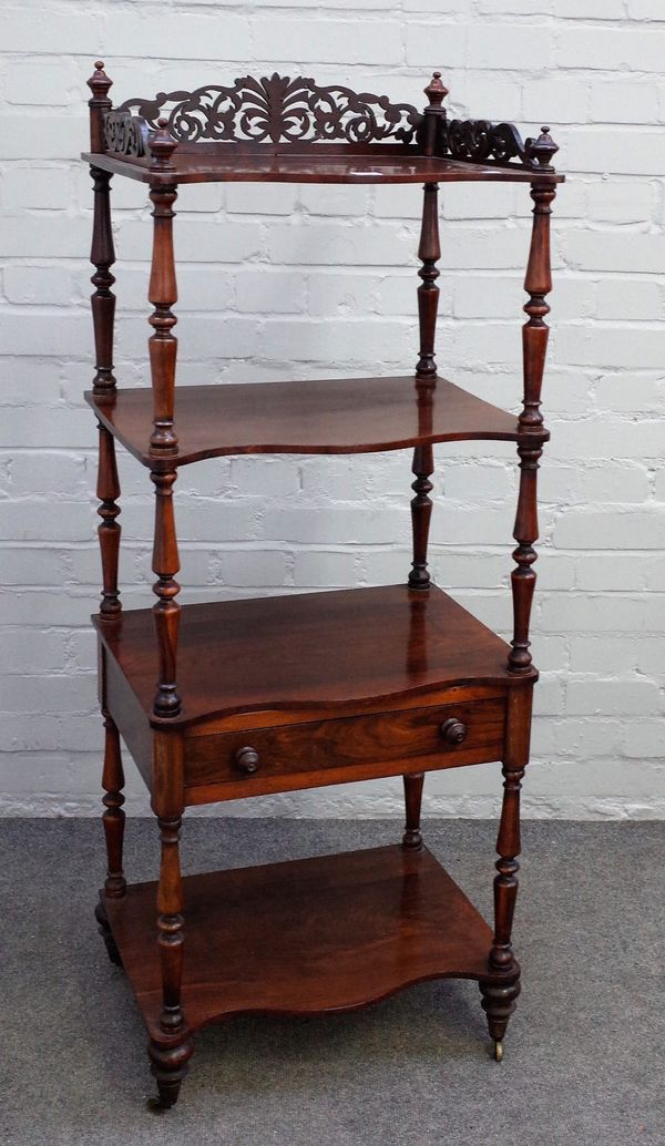 A Victorian rosewood what-not, with fret carved gallery over four serpentine tiers, one with drawer, on turned supports, 51cm wide x 130cm high.