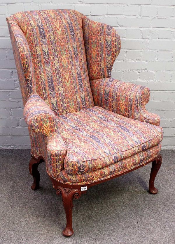 A George I style walnut framed wing back armchair, with bow seat, on scroll capped pad feet, 92cm wide 112cm high.