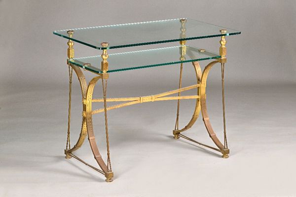 A mid- 20th century French centre table, the rectangular glass top on dual lacquered brass and steel supports, 100cm wide x 80cm high. Illustrated.