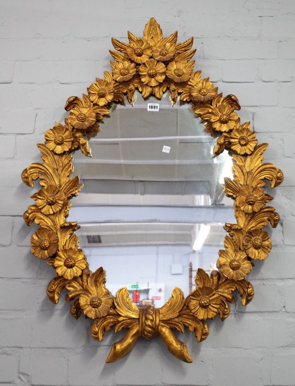 A late 19th century gilt framed mirror with extensive floral relief frame, 66cm wide x 92cm high.